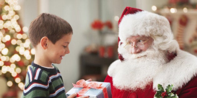 Santa giving Caucasian boy Christmas gift