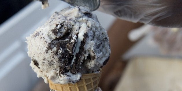 An employee of Ben & Jerry's scoops ice cream into a cone outside Union Station in Washington on June 18, 2013. AFP PHOTO / Saul LOEB (Photo credit should read SAUL LOEB/AFP/Getty Images)