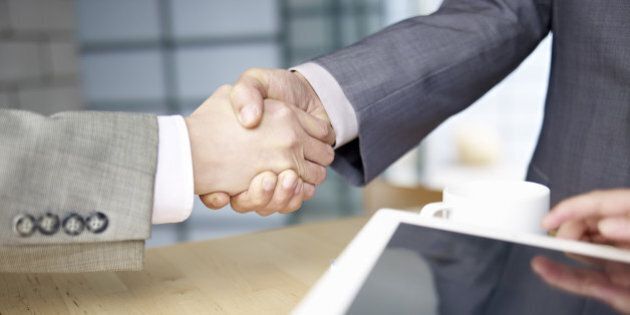 business people shaking hands in office.
