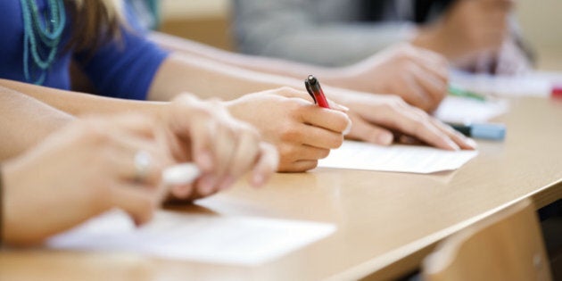 Close-up of writing hands of students at course