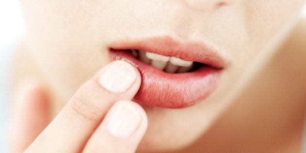 close-up of a woman's hand touching her lip