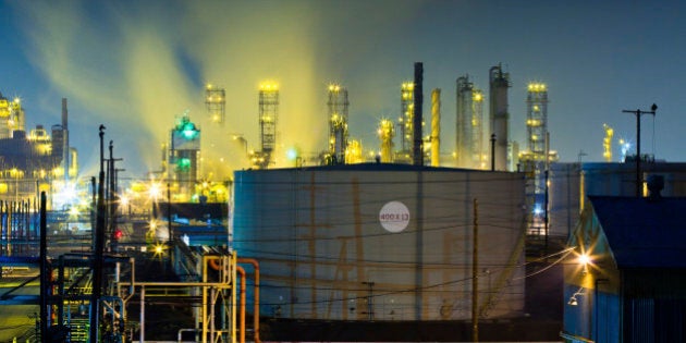 Hundreds of various colored safety lights illuminate rising vapor trails at a large oil refinery complex near Los Angeles at night.