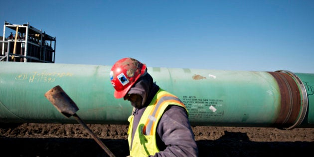 A worker carries a torch after heating a pipe joint during construction of the Gulf Coast Project pipeline in Atoka, Oklahoma, U.S., on Monday, March 11, 2013. The Gulf Coast Project, a 485-mile crude oil pipeline being constructed by TransCanada Corp., is part of the Keystone XL Pipeline Project and will run from Cushing, Oklahoma to Nederland, Texas. Photographer: Daniel Acker/Bloomberg via Getty Images