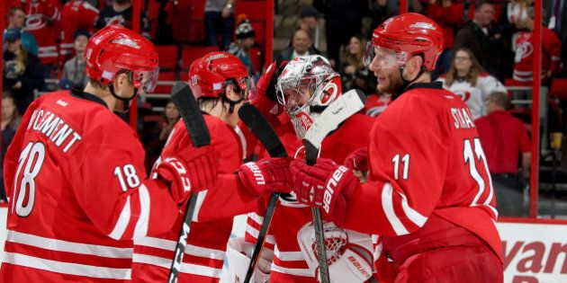 RALEIGH, NC - NOVEMBER 15: Cam Ward #30 of the Carolina Hurricanes is congratulated by teammates on his shutout win against the San Jose Sharks during an NHL game on November 15, 2016 at PNC Arena in Raleigh, North Carolina. (Photo by Gregg Forwerck/NHLI via Getty Images)