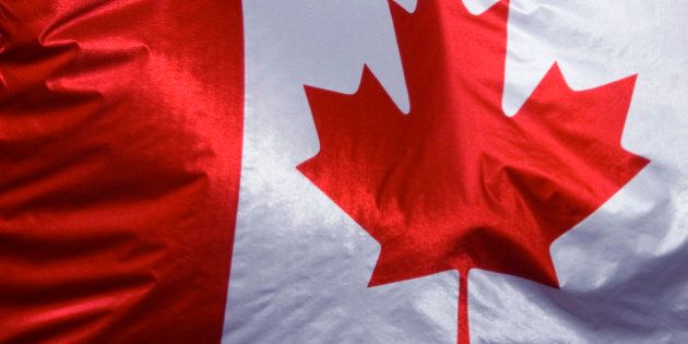 Close up of Canadian flag, hanging from a building.