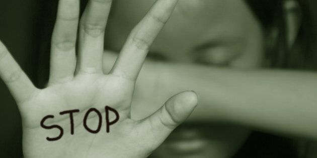 Little girl suffering bullying raises her palm asking to stop the violence in sepia color