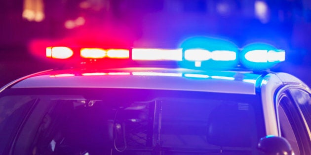 The roof of a police patrol car at night, with the blue and red lights flashing.