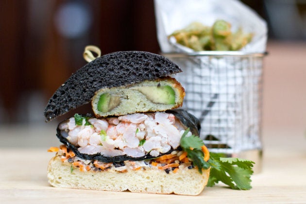 Pain burger à l'encre de seiche et poivre noir, avocat frit, wasabi, sauce soya , crevettes de Matane enveloppées dans des algues de Nori, gingembre frais haché, radis japonais râpé, carotte râpée.