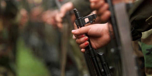 A Colombian guerilla woman holds her AK-47 as she takes part in a line of rebels during an army parade of fighters of the FARC in Villa Colombia camp near San Vicente del Caguan, Caqueta province, Colombia, April 29, 2000. REUTERS/Jose Miguel Gomez/File Photo