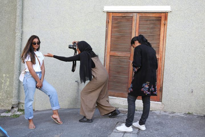 Jeunes femmes prenant des photos à l'extérieur de la mosquée Auwal à Bo-Kaap.