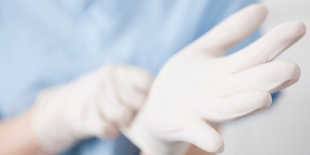 Close-up of female surgeon putting on gloves