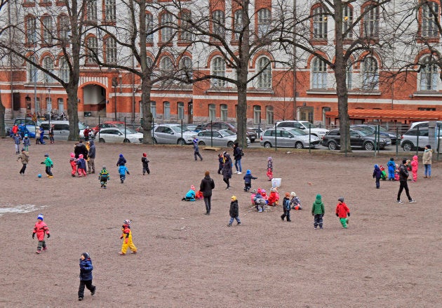 Des enfants jouent dans une cour d'école dehors à Helsinki, en Finlande.