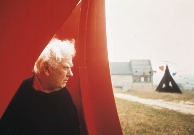 Alexander Calder pose à l'intérieur de l'une de ses oeuvres près de sa maison à Saché, en France.