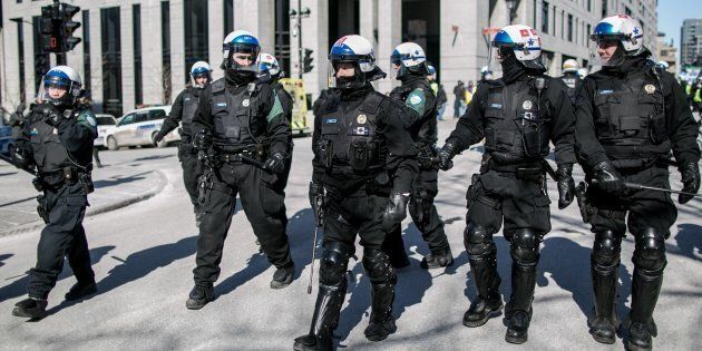 La police de Montréal monte la garde devant l'hôtel de ville durant une manifestation.