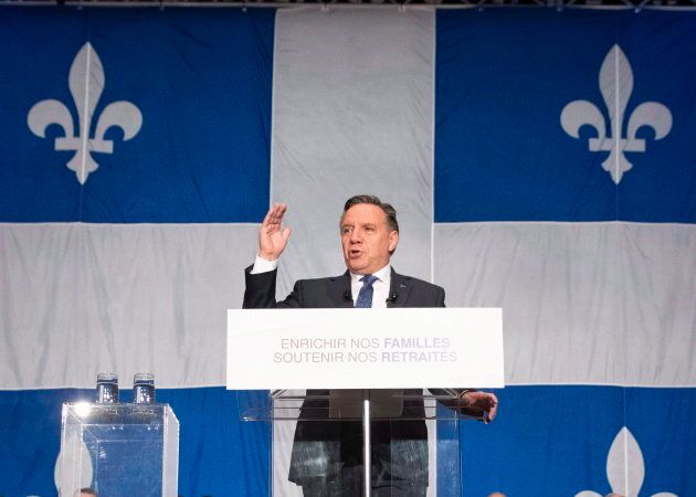 Le premier ministre du Québec devant un très grand drapeau lors de la mise à jour économique de la province, le 3 décembre 2018.