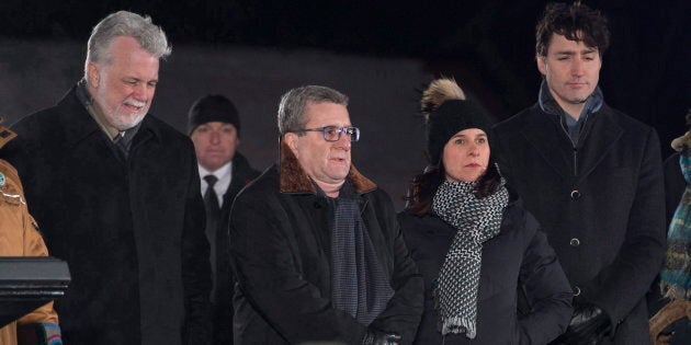 Le premier ministre du Québec (de l'époque), Philippe Couillard, à gauche, le maire de la ville de Québec, Régis Labeaume, la mairesse de Montréal, Valérie Plante, et le premier ministre, Justin Trudeau, assistent à une cérémonie organisée lors d'une veillée commémorant le premier anniversaire de la fusillade de la mosquée de Québec, le 29 janvier 2018.