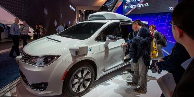 Des curieux regardent la voiture Waymo, anciennement le projet de voiture autonome de Google, lors du CES 2019 de Las Vegas.