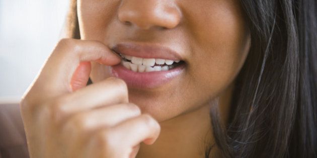 Mixed race woman biting her nail
