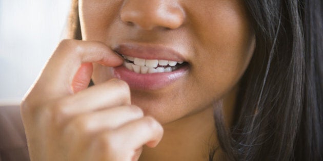 Mixed race woman biting her nail