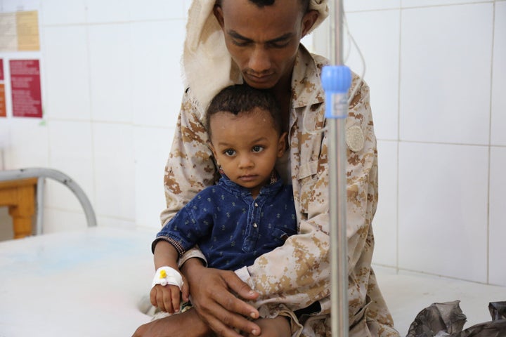 Le lundi 14 août 2017 : Un père tient son enfant souffrant du choléra alors que le petit reçoit un traitement à l'hôpital Alsadaqah d'Aden, au Yémen.