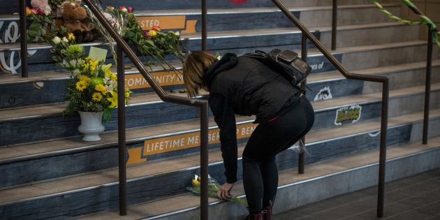 Des membres de la communauté de Humboldt déposent des fleurs sur les marches du Elgar Petersen Arena, la patinoire des Broncos.