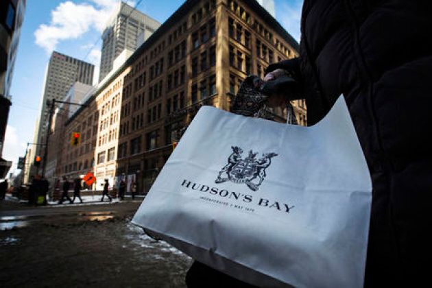 A woman holds a Hudson's Bay shopping bag in front of the Hudson's Bay Company flagship department store in Toronto.