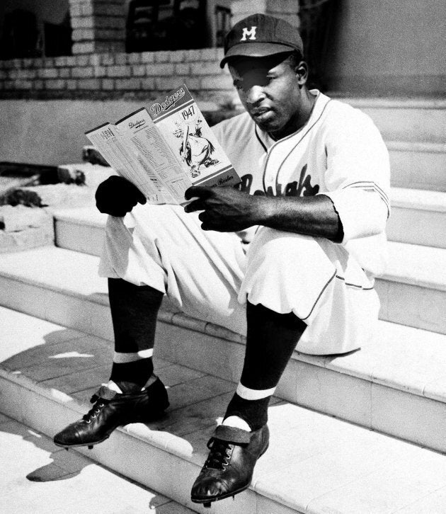 Dans cette photo du 27 février 1947, Jackie Robinson, des Royals de Montréal, examine une liste des Brooklyn Dodgers à La Havane, Cuba, où il s'entraîne avec son équipe.