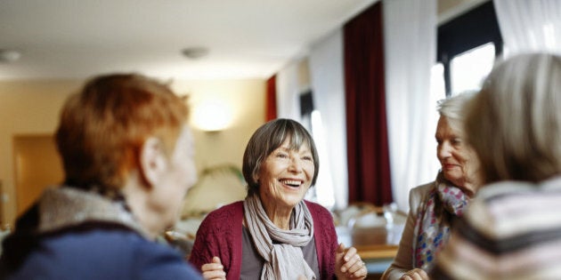 Senior women playing board game in a senior home.