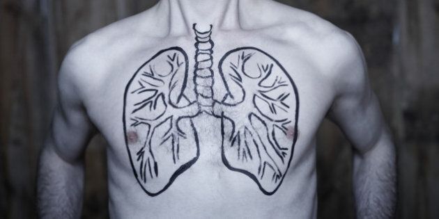 portrait of Man taking a large deep breath with lung illustration drawn on chest