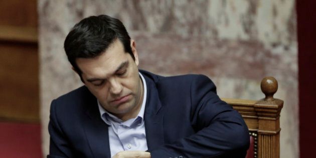 Greece's Prime Minister Alexis Tsipras looks at his watch during a parliament session in Athens, on Tuesday, March 10, 2015. Tsipras spoke during a special debate on whether to revive a parliamentary committee that would seek German World War II reparations that Greece says were never fully paid. The committee would also seek the return of a forced loan raised by Nazi occupation forces, and of Greek antiquities removed during the war.(AP Photo/Petros Giannakouris)