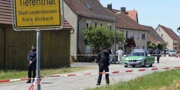 Policemen are seen at a crime scene in Tiefenthal-Leutershausen near Ansbach, southern Germany, after a gunman in a car killed a woman and a cyclist in drive-by shootings on July 10, 2015. The shooter, travelling in a silver Mercedes convertible, also fired at or threatened a farmer and another motorist, before being arrested at a petrol station near the shootings. AFP PHOTO / THOMAS KIENZLE (Photo credit should read THOMAS KIENZLE/AFP/Getty Images)