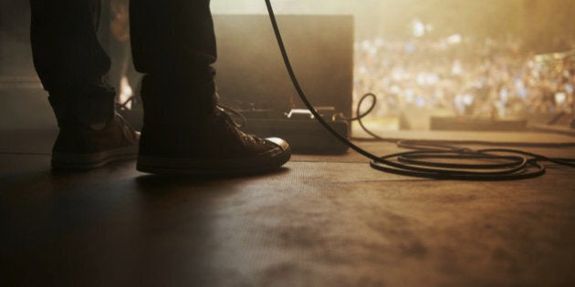 Cropped shot of a musician's feet on stage at an outdoor music festival