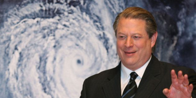 Former Vice President Al Gore acknowledges spectators in front of a poster of his starring documentary film