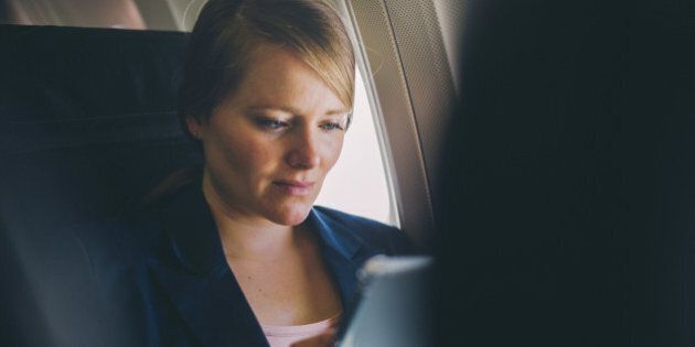 Woman using mobile device in a plane.