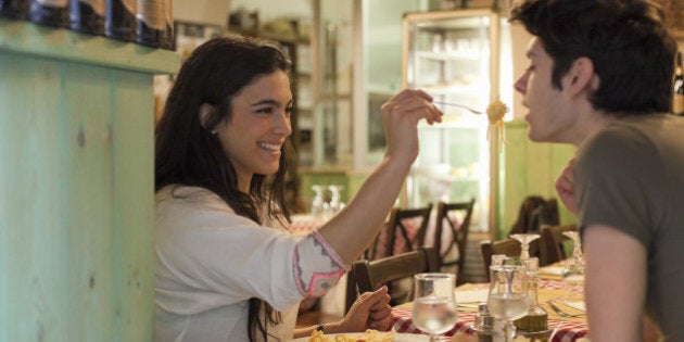 happy young couple eating together in restaurant