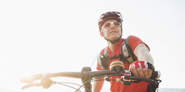 Caucasian man pushing mountain bike