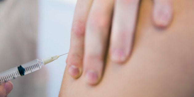 Cropped image of doctor injecting patient in clinic