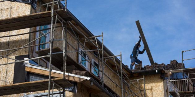 A contractor moves roofing material on a home under construction at the Toll Brothers Inc. Cantera at Gale Ranch housing development in San Ramon, California, U.S., on Wednesday, Jan. 20, 2016. The U.S. Census Bureau reported a drop in new-home construction for December which probably reflects little more than a pause in a steady uptrend, as housing starts closed out the strongest year since 2007. Photographer: David Paul Morris/Bloomberg via Getty Images