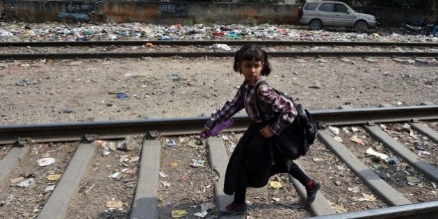 An Indian girl walks along train tracks in New Delhi on October 13, 2015 near where a four-year-old girl was raped. Indian police said they have arrested the main suspect in a horrific attack on a four-year-old girl who was raped and slashed with a blade before being abandoned by a railway track. AFP PHOTO / MONEY SHARMA (Photo credit should read MONEY SHARMA/AFP/Getty Images)