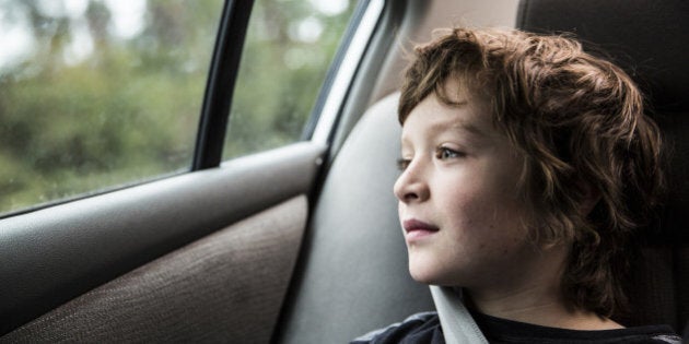 Boy (9 in backseat of car, looking out window