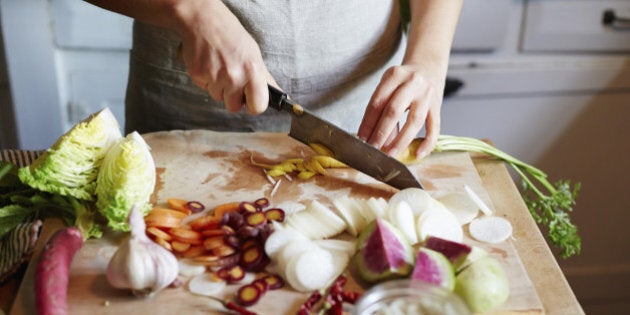 Woman cooking in kitchen with ingredients around her