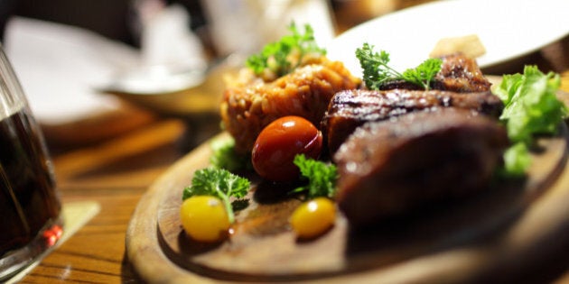 The pork ribs with vegetables on the wooden plate