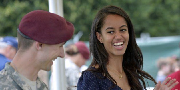 Malia Obama, daughter of US President, (R) smiles as she serves food during a lunch at the United States and Nato military base in Vicenza on June 19, 2015 . AFP PHOTO / ANDREAS SOLARO (Photo credit should read ANDREAS SOLARO/AFP/Getty Images)