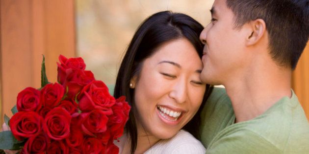 Young Couple Hugging and Kissing with Roses