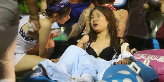 Injured victims from an explosion during a music concert are tended to at the Formosa Water Park in New Taipei City, Taiwan, Saturday, June 27, 2015. The New Taipei City fire department says 200 people were injured in an accidental explosion of colored theatrical powder Saturday night, near a performance stage where about 1,000 people were gathered for party. (AP Photo) TAIWAN OUT