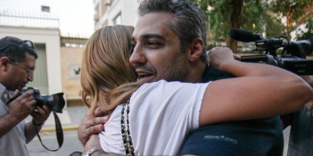 ==EGYPT OUT==Canadian Al-Jazeera journalist Mohamed Fahmy (R) hugs his wife Marwa after being dropped off by authorities in the upmarket Cairo suburb of Maadi following his release from prison with his colleague Baher Mohamed after being pardoned by Egyptian President Abdel Fattah al-Sisi on September 23, 2015. Sisi pardoned the two Al-Jazeera colleagues, along with 100 prisoners, the presidency and official media reported. AFP PHOTO / STR (Photo credit should read STR/AFP/Getty Images)
