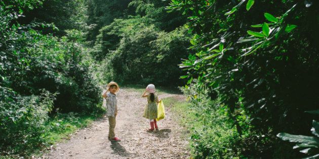 2 young friends walking down a forest track.