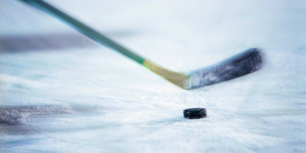 View of an ice hockey stick about to hit the puck