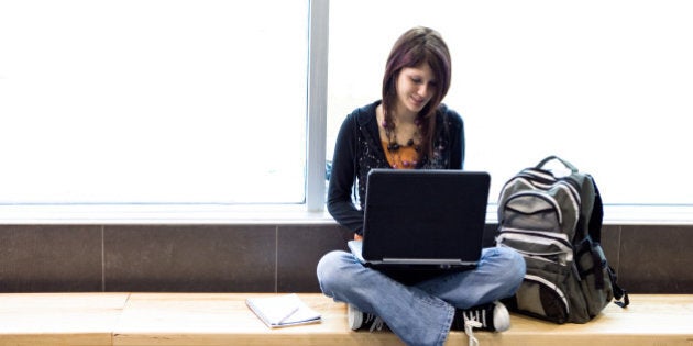 Teenage girl using computer by window