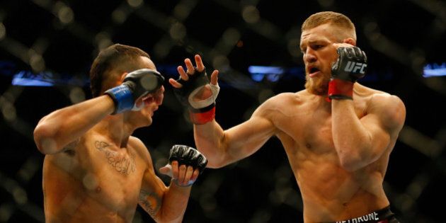 BOSTON, MA - AUGUST 17: Conor McGregor punches Max Holloway in their featherweight bout at TD Garden on August 17, 2013 in Boston, Massachusetts. (Photo by Jared Wickerham/Getty Images)